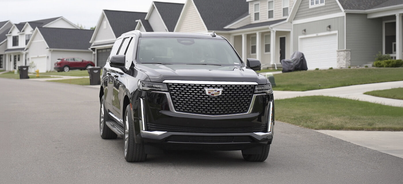 A Cadillac Escalade driving through a neighborhood