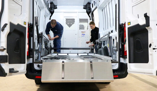 2 individuals installing the lower deck of the DD2000-XLC into a Ford e-Transit